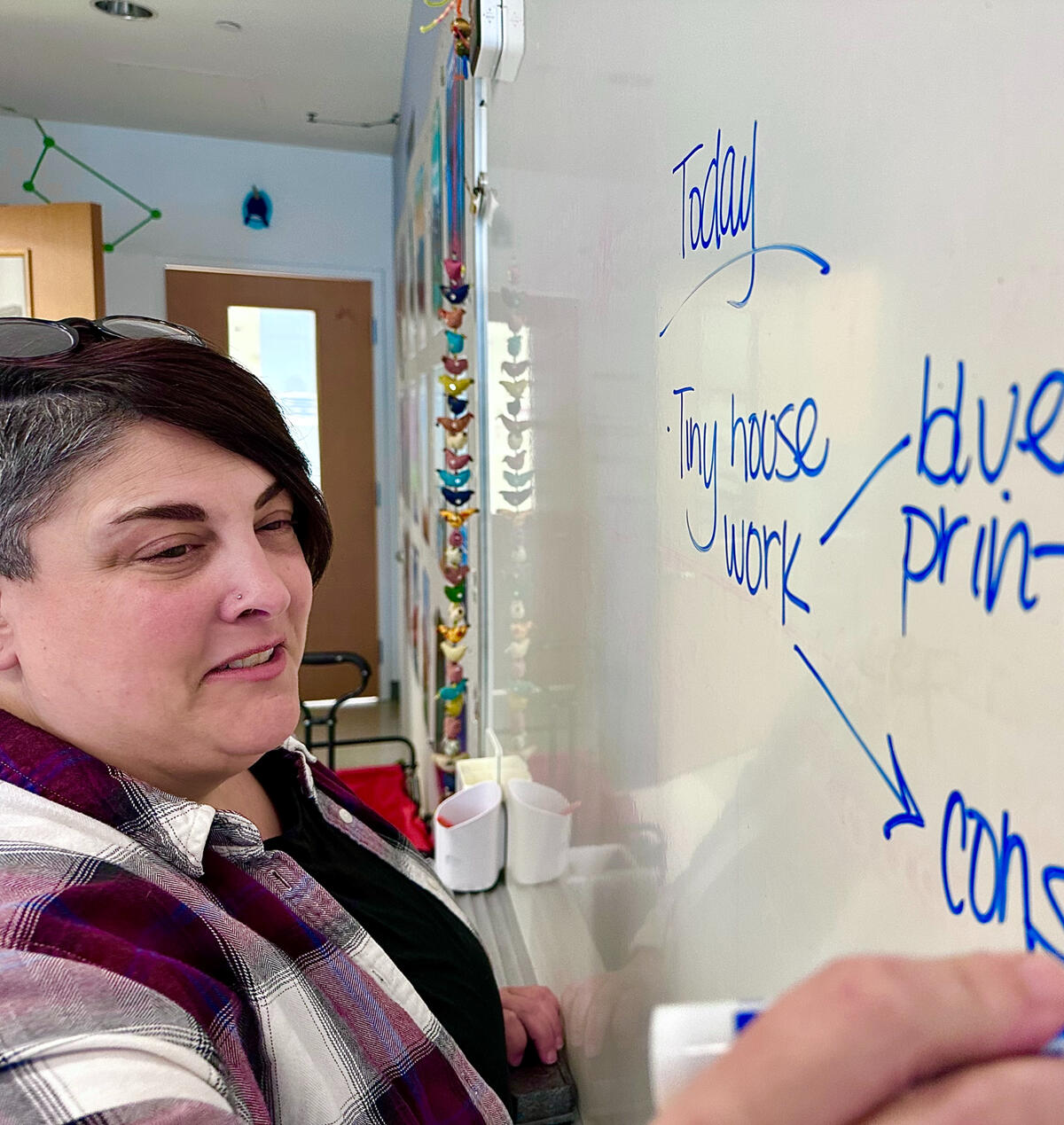 Seventh-grade science teacher Amy Cataldo writing out her class's agenda on a classroom whiteboard